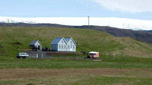 A small farmhouse stands below the Myrdalsjokull glacier that covers the Katla volcano in Evindarholar Iceland