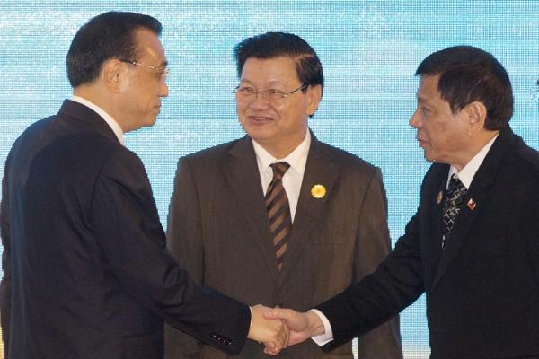 Chinese Premier Li Keqiang left shakes hands with Philippine's President Rodrigo Duterte right as Laos&#39 Prime Minister Thongloun Sisoulith watches during the 19th ASEAN-China summit in Vientiane Laos Sept. 7 2016. (AP