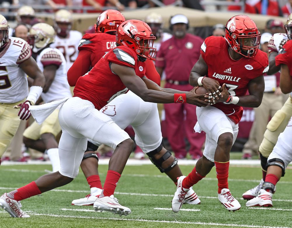 Louisville quarterback Lamar Jackson fakes a handoff to Brandon Radcliff during the first quarter of an NCAA college football game Saturday Sep. 17 2016 in Louisville Ky