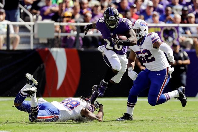 Baltimore Ravens running back Terrance West breaks a tackle by Buffalo Bills cornerback Ronald Darby as he runs past Buffalo Bills middle linebacker Preston Brown during the first half of an NFL football game in Baltimore Sunday Sept. 11