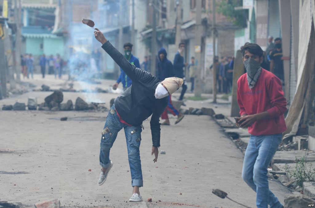 India- A Kashmiri protestor throws a stone towards Indian government forces during clashes in Srinagar