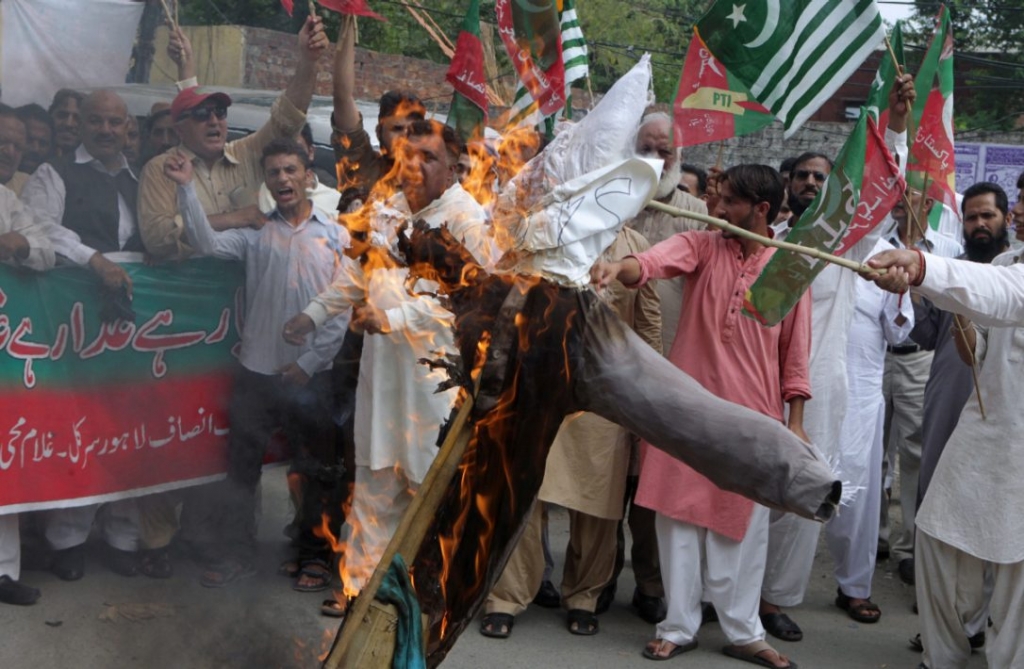 Supporters of Pakistan Tehreek-e Insaf party burn effigy of Indian Prime Minister Narendra Modi during a demonstration in Lahore Pakistan on Sunday. Protesters condemned the killing of Kashmiri resistance leader Burhan Wani by Indian forces and expressed