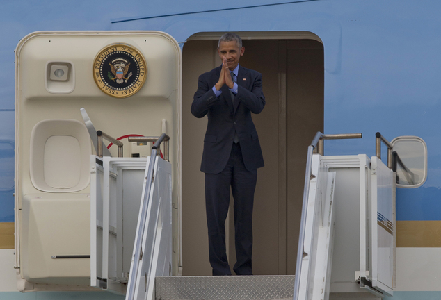 U.S. President Barack Obama clasps his hands to bid farewell from Air Force One just before taking off at Wattay International Airport in Vientiane Laos Th