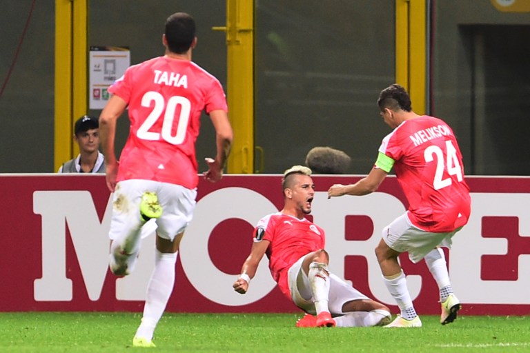 Hapoel Beersheba's midfielder Maor Buzaglo celebrates with teammates after scoring a goal during the Europa League football match against Inter Milan