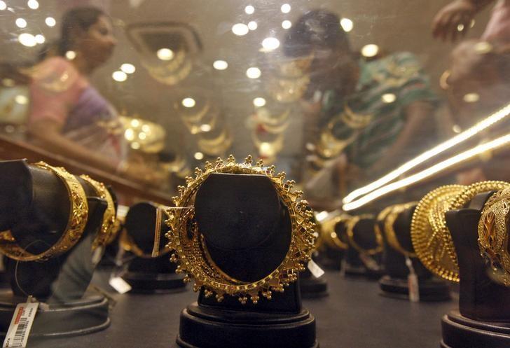 Gold bracelets are on display as a woman makes choices at a jewellery showroom on the occasion of Akshaya Tritiya a major gold buying festival in Kolkata