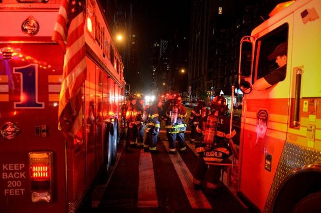 New York City firefighters stand near the site of an explosion in the Chelsea neighborhood of Manhattan New York US