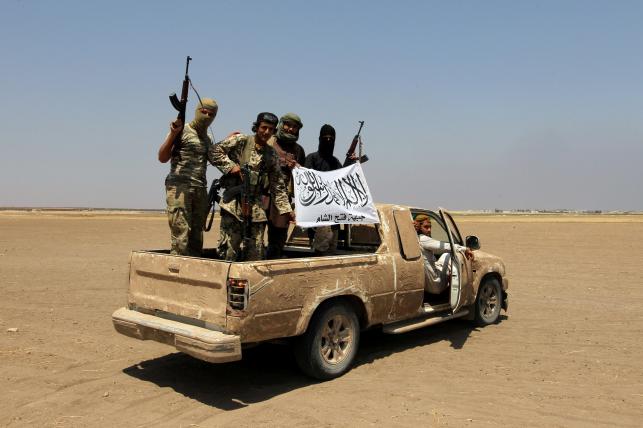 Fighters of the Syrian Islamist rebel group Jabhat Fateh al Sham cheer after a Russian helicopter was shot down in the north of Syria`s rebel-held Idlib province Syria on 1 August