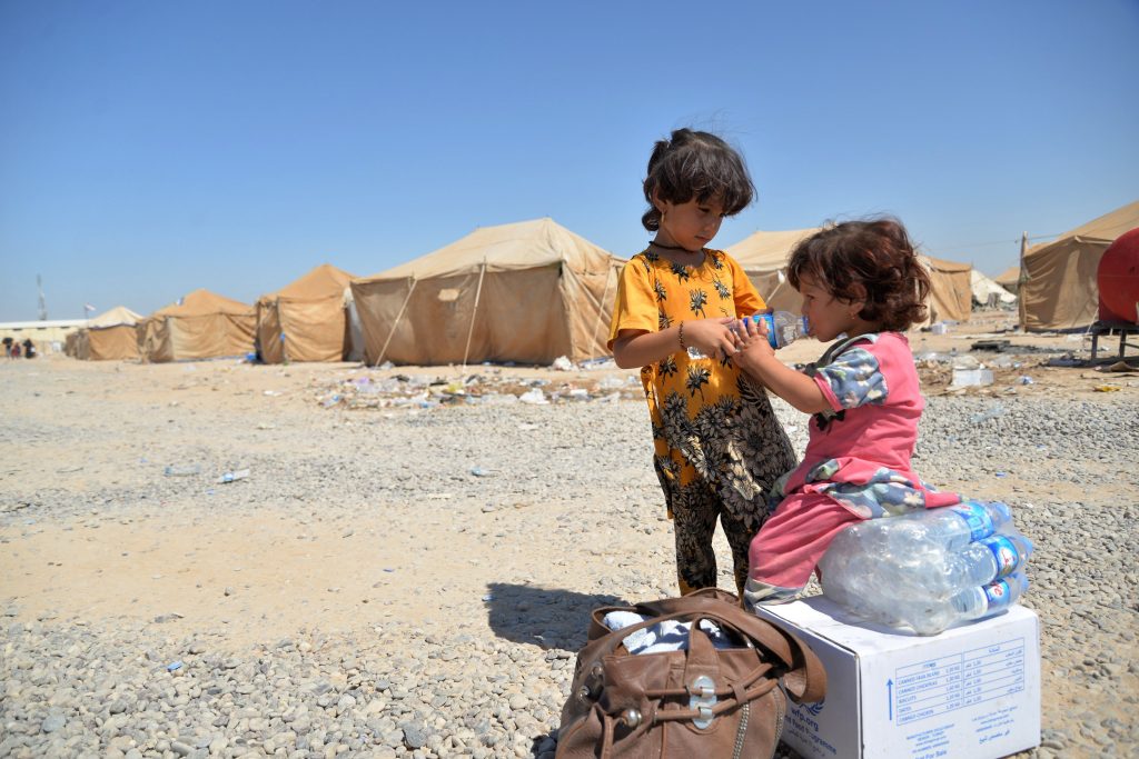 Iraqi displaced children from Syria receive aid supplies at a refugee camp in Baiji north of Baghdad in September 2016