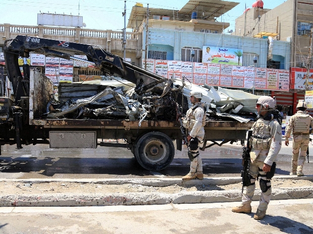 Iraqi security forces stand near the site of a bomb attack in Baghdad northern Shaab district Iraq