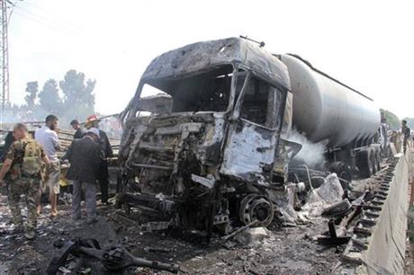 Syrian official news agency SANA Syrian security forces emergency services and residents look at the remains of burned vehicles at the site of a bombing in Tartus Syria Monday Sept. 5 2016. Syrian state media reported