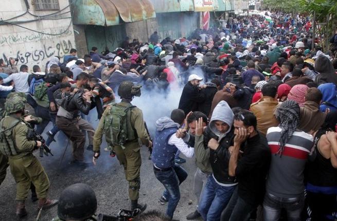 Israeli security forces fire tear gas canisters to disperse Palestinian protesters during a demonstration