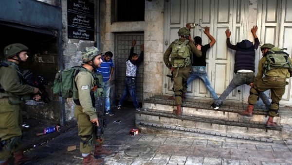 Israeli soldiers search Palestinians during clashes in the West Bank city of Hebron Sept. 19 2016