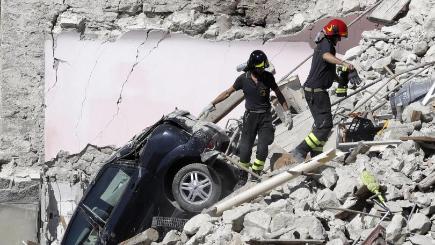 Rescuers make their way through destroyed houses following Wednesday's earthquake in Italy