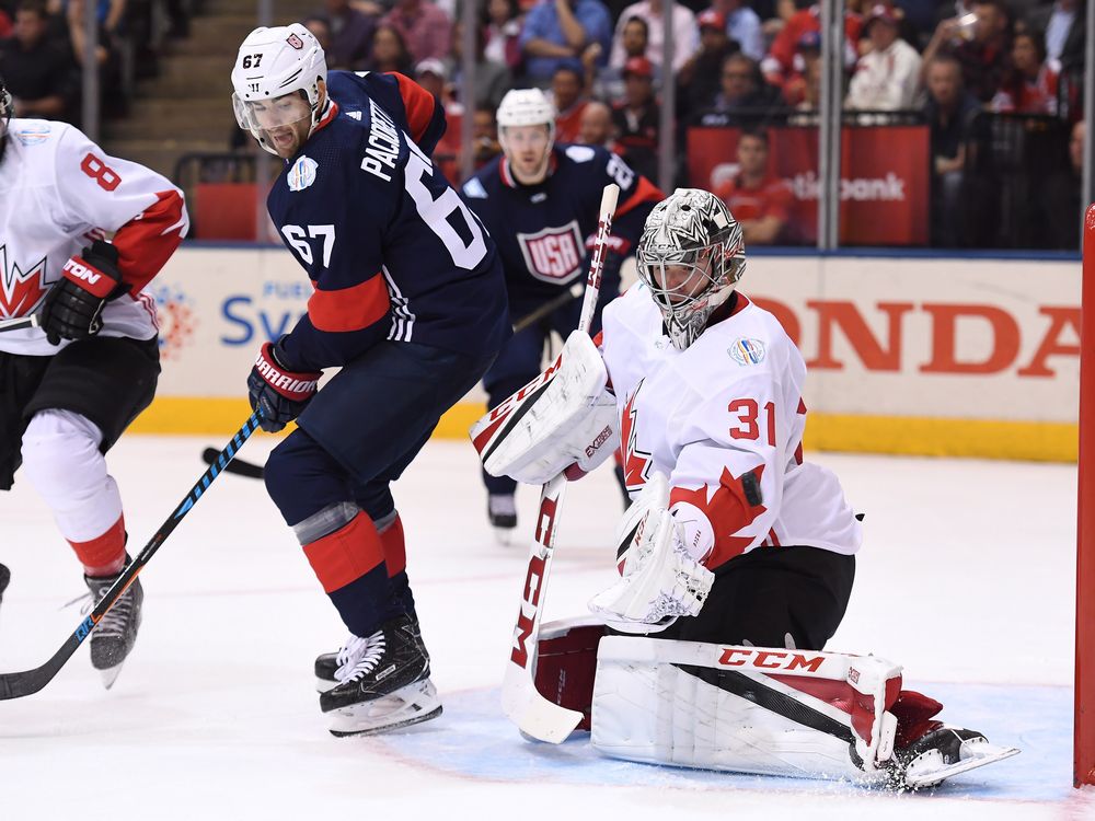 Team USA's Max Pacioretty left stands in front of Team Canada goalie Carey Price as he makes a save during second period World Cup of Hockey action in Toronto on Tuesday