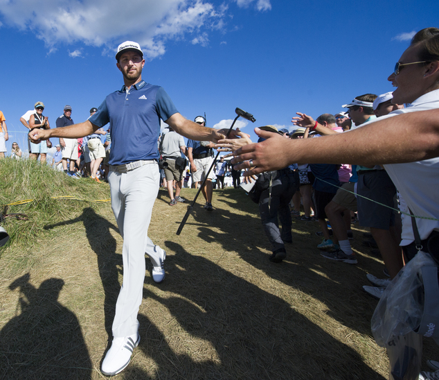 Dustin Johnson is greeted by fans as he walks to the 17th tee box during the final round of the BMW Championship golf tournament at Crooked Stick Golf Club