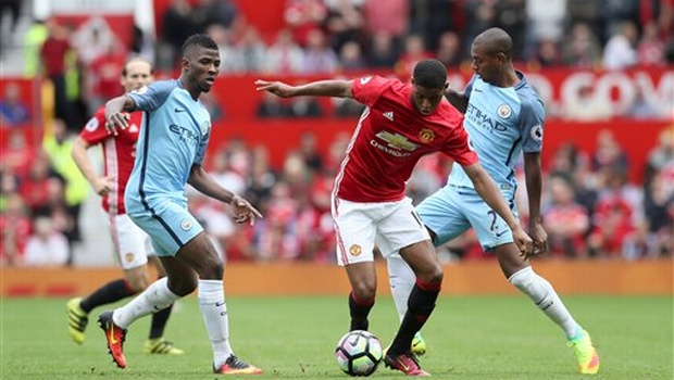 Manchester United's Marcus Rashford center battles for the ball with Manchester City's Kelechi Iheanacho left and Fernandinho during the English Premier League soccer match between Manchester United and Manchester City at Old Trafford Manchester Eng