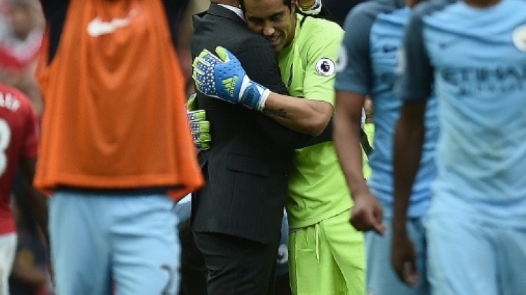 Manchester City's manager Pep Guardiola embraces goalkeeper Claudio Bravo as they celebrate after defeating Manchester United in their English Premier League match at Old Trafford