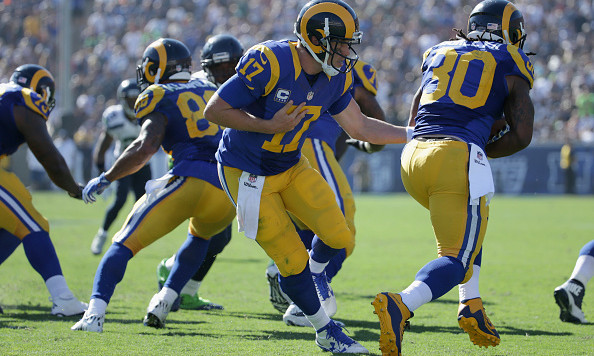 LOS ANGELES CA- SEPTEMBER 18 Quarterback Case Keenum #17 of the Los Angeles Rams hands off to Todd Gurley #30 during the fourth quarter of the home opening NFL game against the Seattle Seahawks at Los Angeles Coliseum