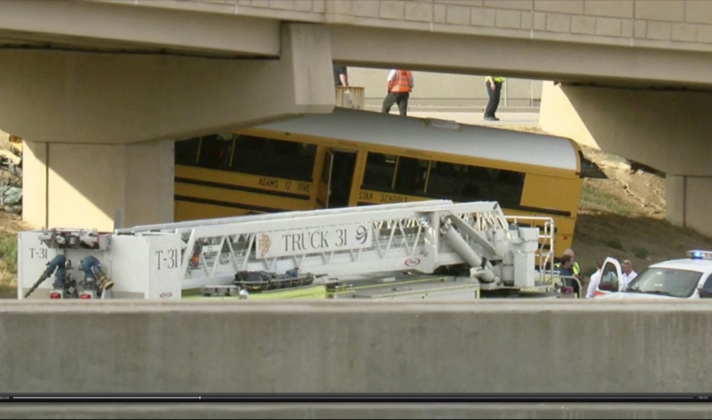 Emergency personnel stand near the scene of a school bus that crashed into a concrete pillar in Denver on Sept. 11 2016