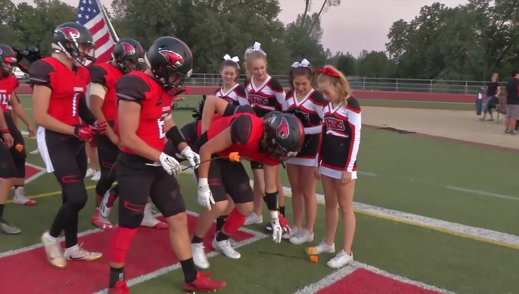 Local cheerleader battling cancer gets rosy support from football team