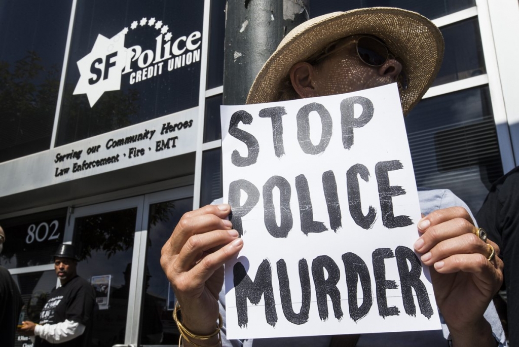 Melissa Hafez holds a sign during a protest outside the San Francisco Police Officers Association in San Francisco Calif. Wednesday