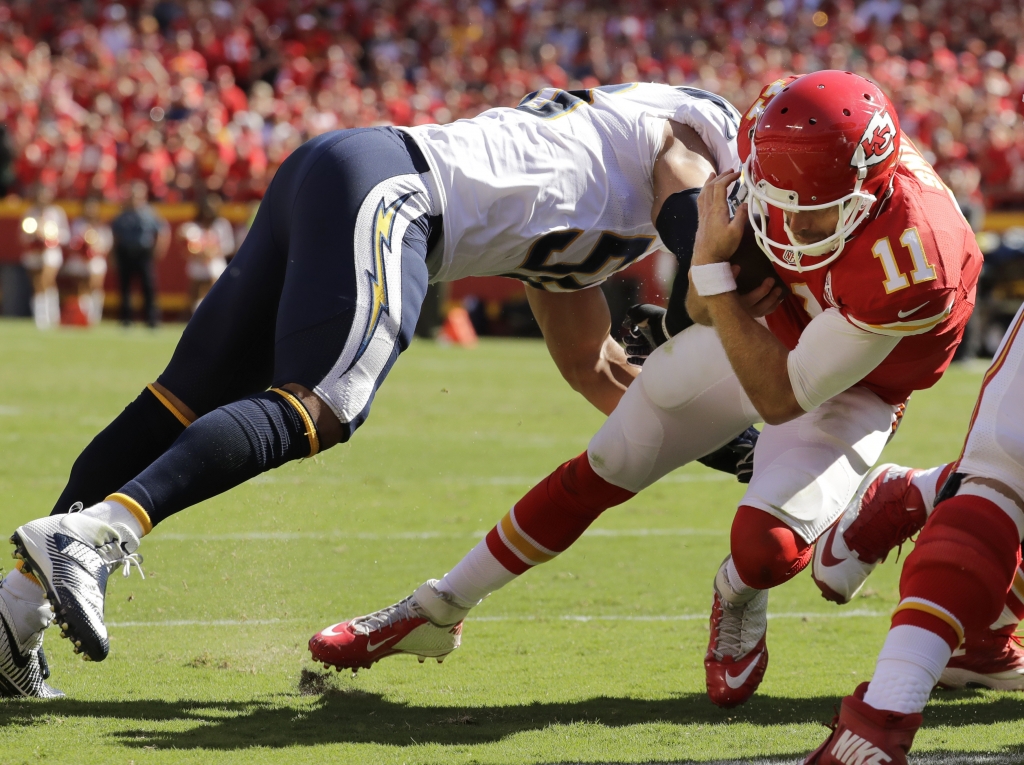 Kansas City Chiefs quarterback Alex Smith carries the ball into the end zone past San Diego Chargers linebacker Tourek Williams to win the game during overtime in an NFL football game in Kansas City Mo. Sunday Sept. 11 2016. The Kansas City