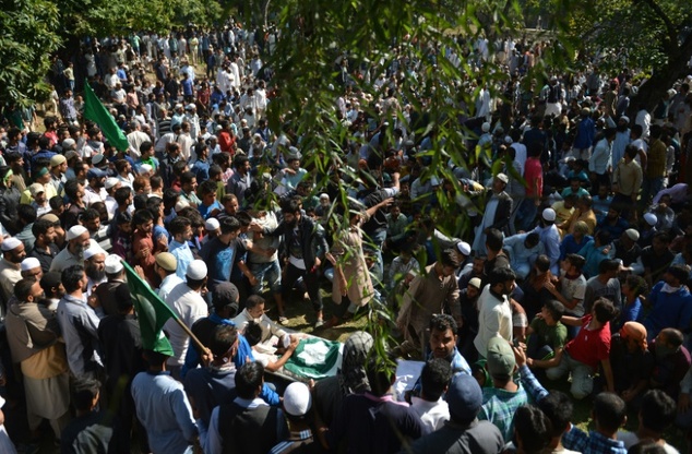 Kashmiri mourners shout slogans near the body of Nasir Shafi 11 during his funeral in Srinagar