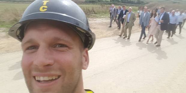 A construction worker snaps a selfie with Prince William and Catherine as they visit a housing project site in Newquay United Kingdom