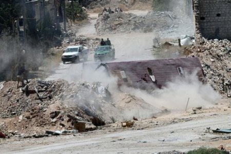 Forces loyal to Syria's President Bashar al Assad are seen near barricades after they advanced on the southern side of the Castello road in Aleppo Syria in this handout