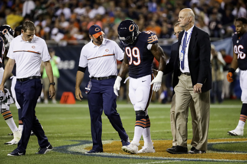 Lamarr Houston goes off the field with athletic trainers after being injured against the Eagles at Soldier Field on September 19th