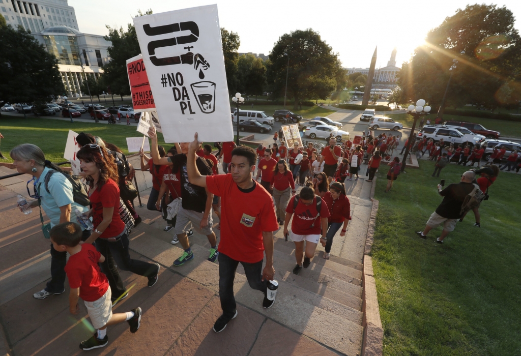 A line of protesters against the construction of the Dakota Access oil pipeline on the Standing Rock Reservation in North Dakota head to a unity rally on the west steps of the State Capitol late Thursday Sept. 8 2016 in Denver. Several hundred marchers