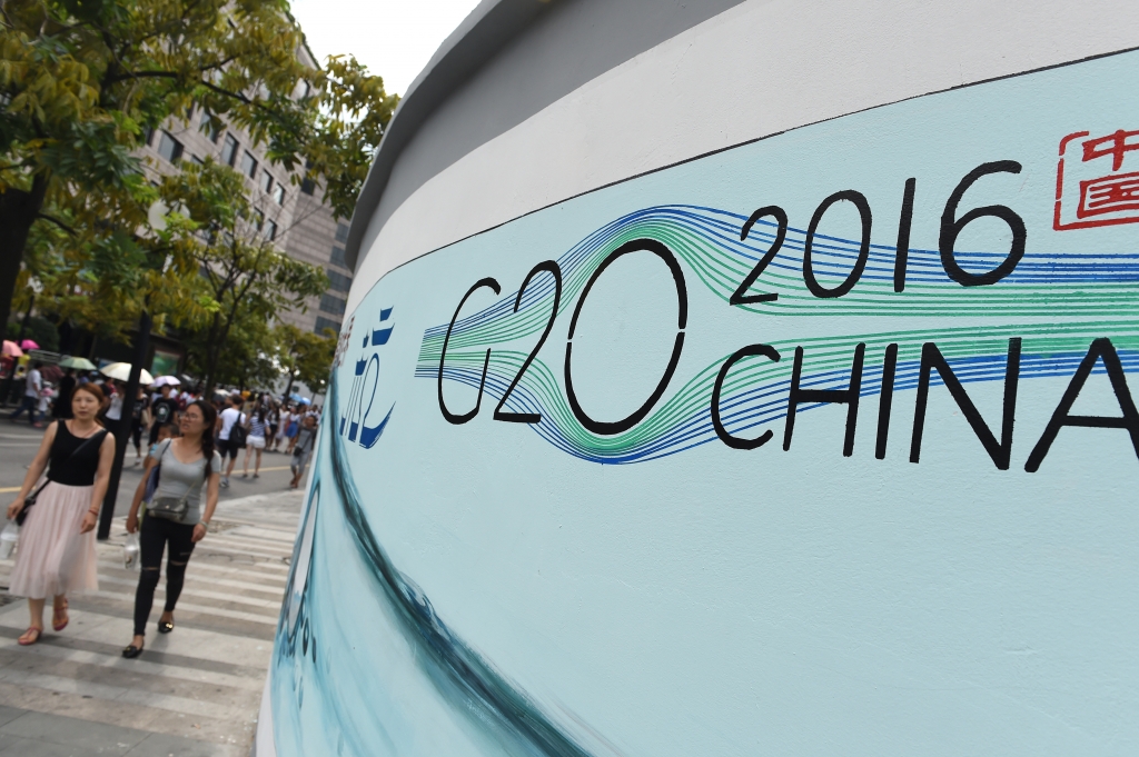 HANGZHOU Aug. 28 2016 - People walk past a G20 themed poster in Hangzhou capital of east China's Zhejiang Province Aug. 27 2016. The 11th G20 summit will be held from Sept. 4 to 5 in Hangzhou