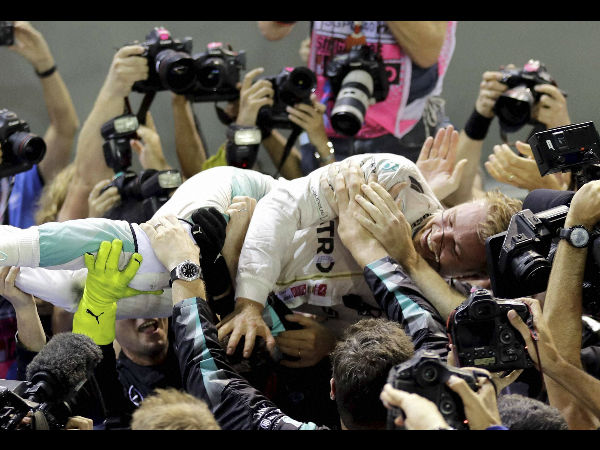 Mercedes driver Nico Rosberg of Germany is embraced by his team after winning the Singapore Formula One Grand Prix on the Marina Bay City Circuit Singapore Sunday Sept. 18 2016