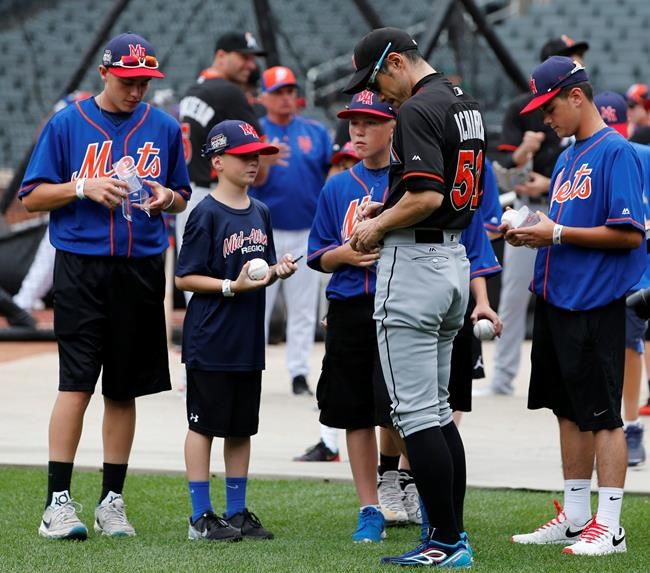 Miami Marlins&#39 Ichiro Suzuki signs autographs for members of the Little League World Series winning team from Endwell N.Y. during batting practice before a baseball game between the New York Mets and the Marlins Wednesday Aug. 31 2016 in Ne