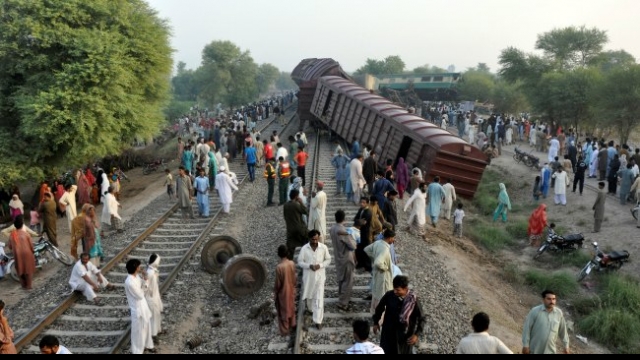 Locals mill around the scene where two trains collided near Multan Pakistan