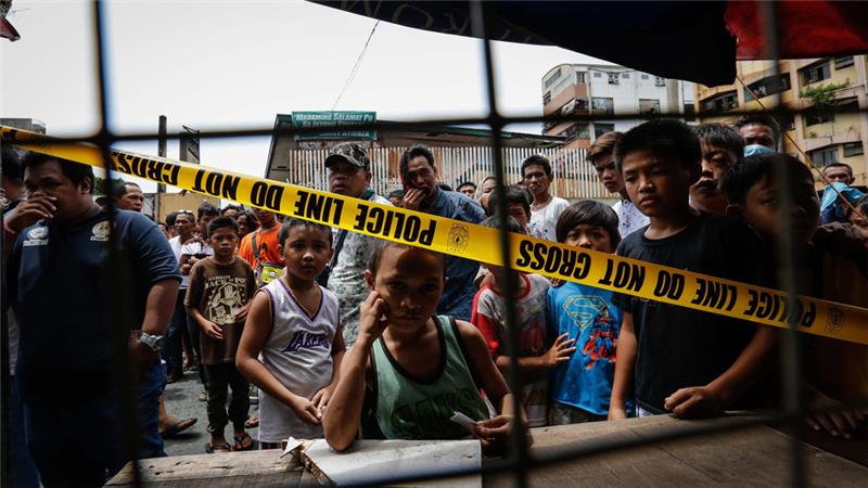 Local children peer into cordoned area following a police operation against illegal drugs in Manila Philippines EPA