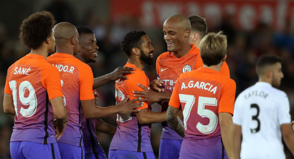 Manchester City players celebrate Gael Clichy’s first goal of the game at the Liberty Stadium