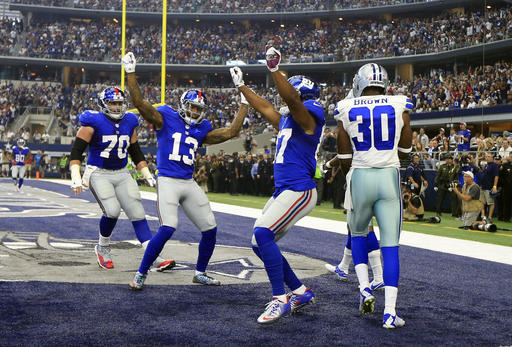 New York Giants center Weston Richburg and Odell Beckham celebrate with Sterling Shepard second from right after Shepard caught a pass for a touchdown in front of Dallas Cowboys cornerback Anthony Brown in the first half of an NFL footbal