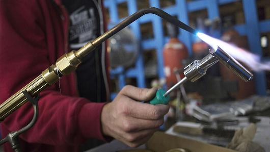 A worker uses a torch at the Watermark Designs manufacturing facility in Brooklyn New York