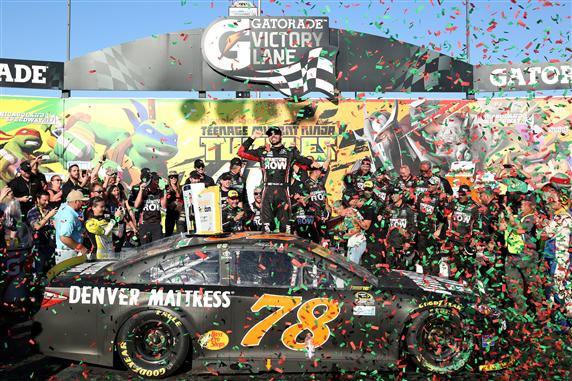 Martin Truex Jr celebrates in Victory Lane at Chicagoland Speedway after winning the NASCAR Sprint Cup Series Teenage Mutant Ninja Turtles 400