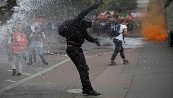 Masked protesters clash with French riot police as they take part in a march against the new French labour law Sept. 15 2016