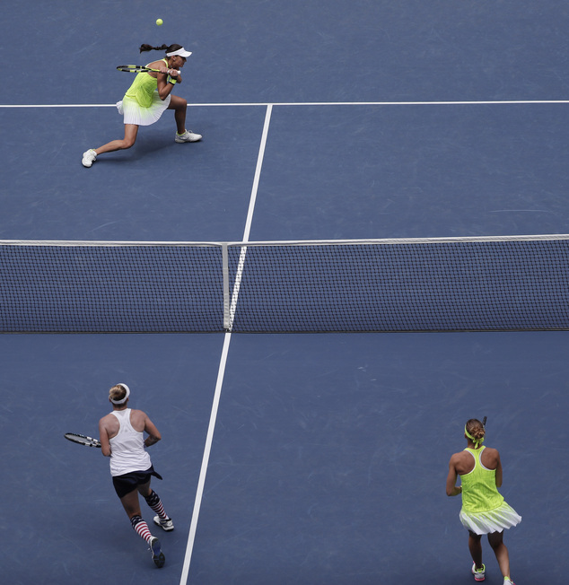 Caroline Garcia of France returns a shot to Bethanie Mattek-Sands of the United States lower left and Lucie Safarova of the Czech Republic during the