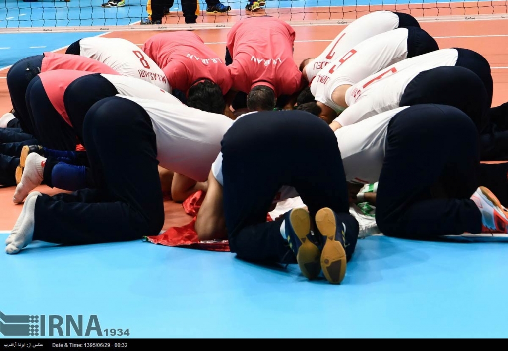 Members of
Iran's national sitting volleyball team pray together after their victory