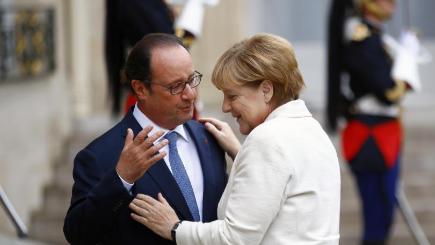 French president Francois Hollande left greets German chancellor Angela Merkel prior to their meeting at the Elysee Palace in Paris