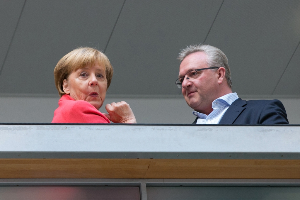 Angela Merkel Germany's chancellor and Christian Democratic Union party leader left reacts as she stands with Frank Henkel the CDU candidate in Berlin ahead of a CDU federal board meeting at the party's headquarters in Berlin Germany on Monda