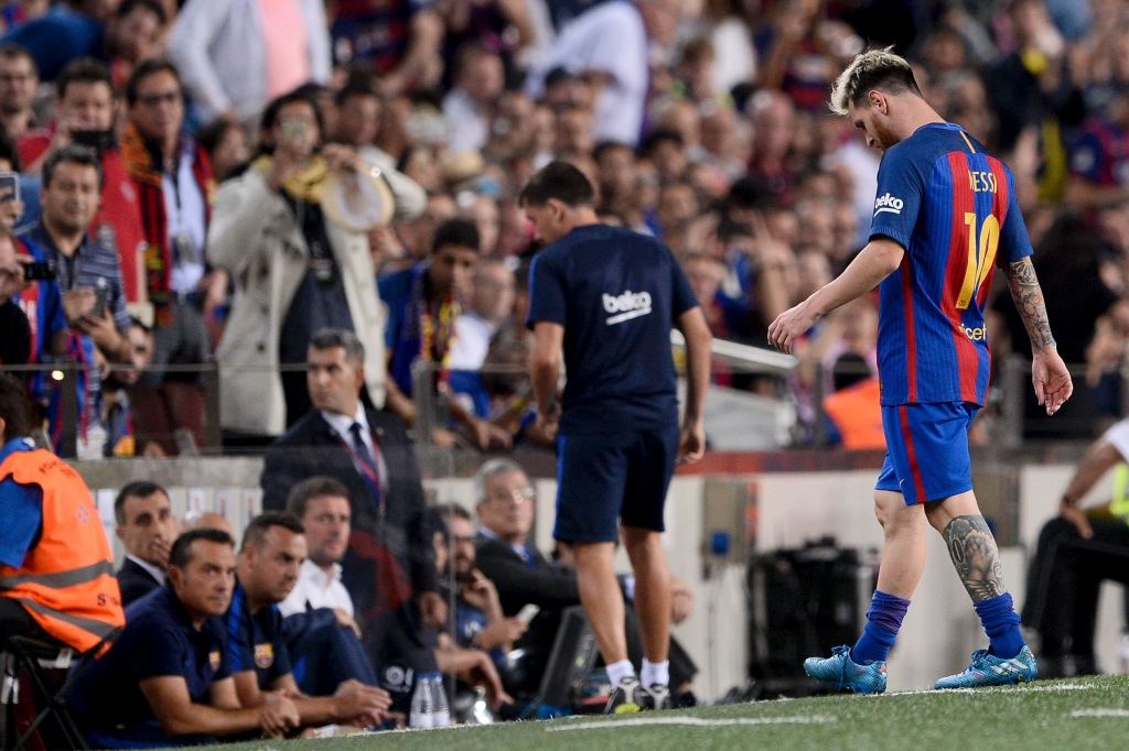 Barcelona's Argentinian forward Lionel Messi leaves the pitch after being injured during the Spanish league football match FC Barcelona vs Atletico de Madrid at the Camp Nou stadium in Barcelona