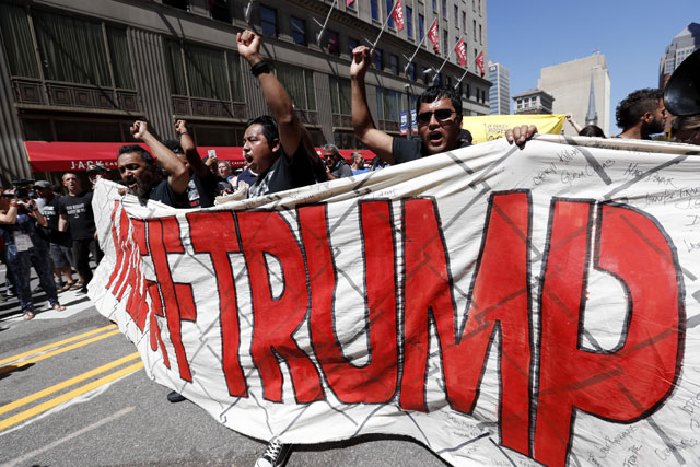 Immigrant rights activists hold up a fabric wall protesting against Republican presidential candidate Donald Trump Wednesday