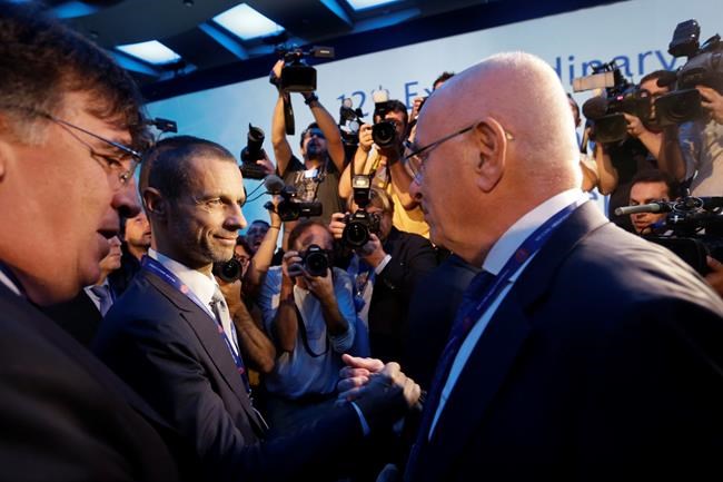 Candidates for the UEFA presidency, Aleksander Ceferin head of the Slovenian Soccer Federation second left and Michael van Praag president of the Dutch Soccer Federation right shake hands in Athens on Wednesday Sept 14 2016. European soccer federa