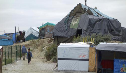 Migrants walk in the northern area of the camp called the'Jungle in Calais France