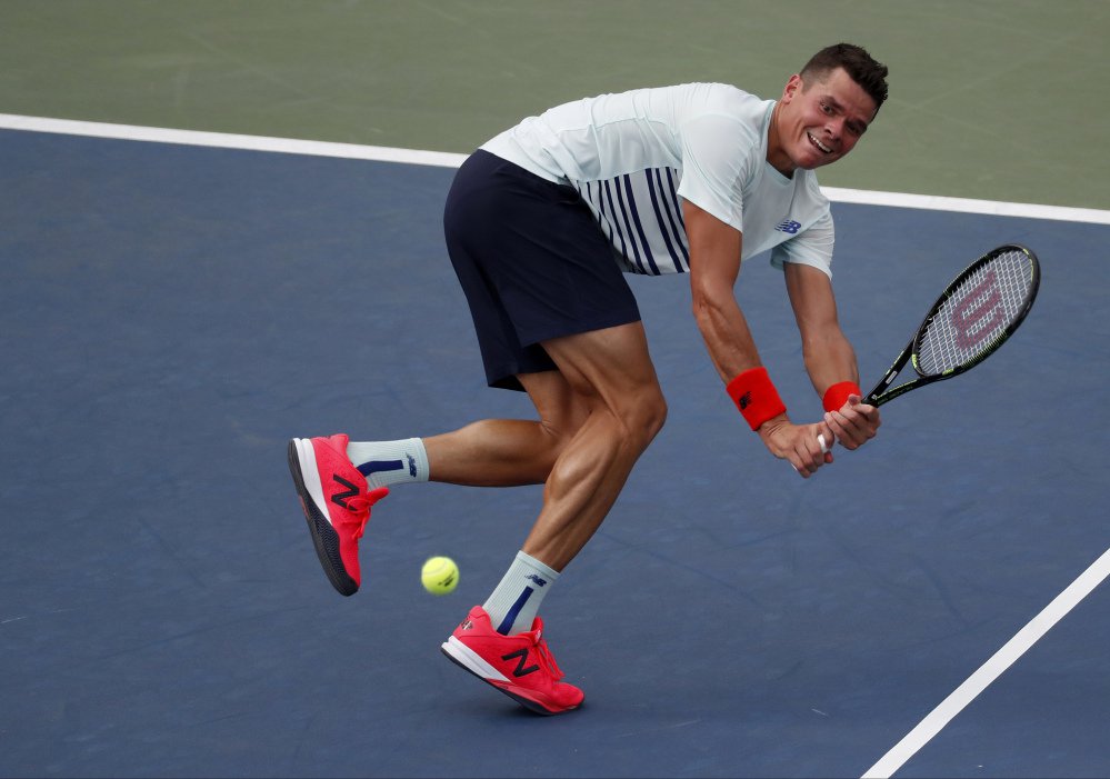 Milos Raonic returns a shot to Ryan Harrison in their second-round match Wednesday at the U.S. Open